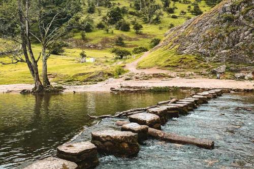 a row of rocks in the water next to a mountain at Barn Conversion - Sleeps 4 - Pet friendly - Garden in Whiston