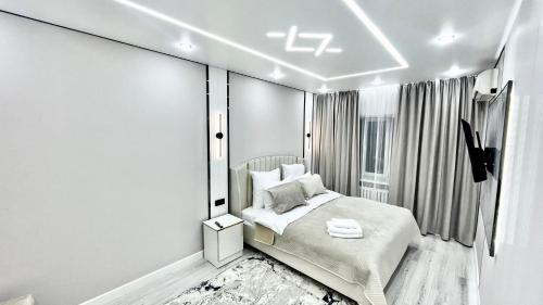 a bedroom with a bed and a window at Люкс квартиры in Taraz