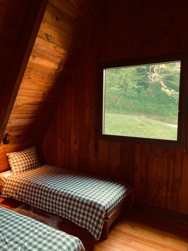 a room with two beds in a cabin with a window at Chalet AbA, proche Luchon in Cierp
