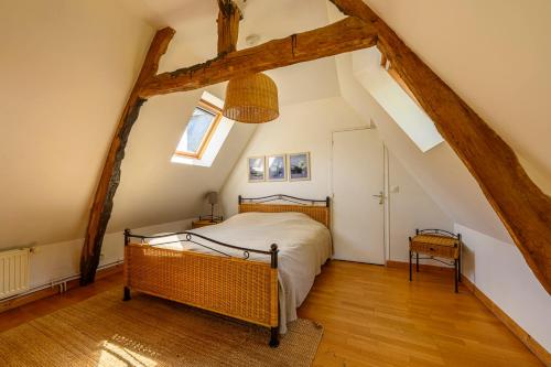 a bedroom with a bed in a attic at Blue cottage in Normandie in Ouville-lʼAbbaye