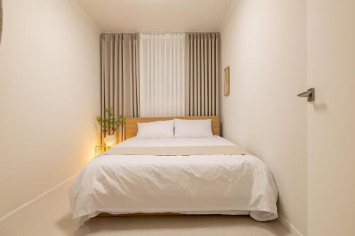 a bedroom with a white bed with a window at Harangae in Seoul
