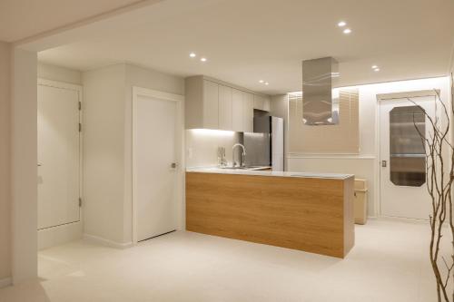a kitchen with white cabinets and a wooden counter top at Harangae in Seoul