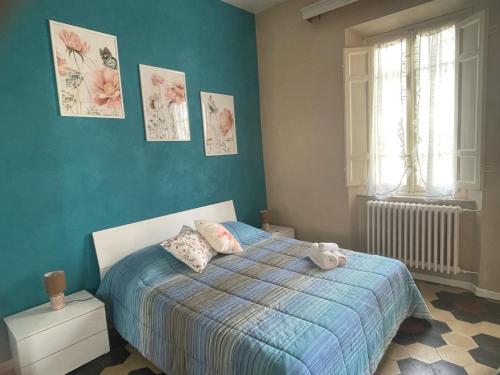 Un dormitorio con una cama con una pared azul. en La casa del Pucci, en Lucca