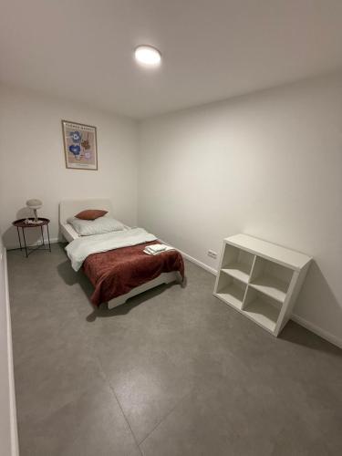 a white bedroom with a bed and a table at Apartment Natalie in Hagen