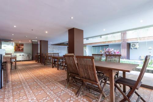 a dining room with wooden tables and chairs at Sans Vibes Residence and Villa Cemagi in Cemagi