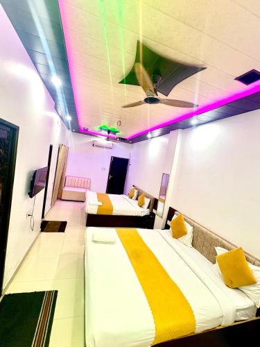 two beds in a room with purple lights at Hotel shiva international in Varanasi