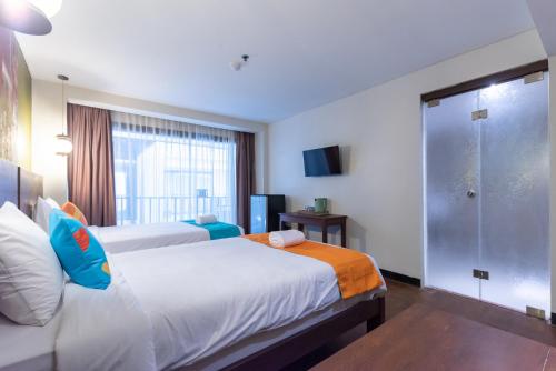 a hotel room with two beds and a shower at Sans Vibes Residence and Villa Cemagi in Cemagi