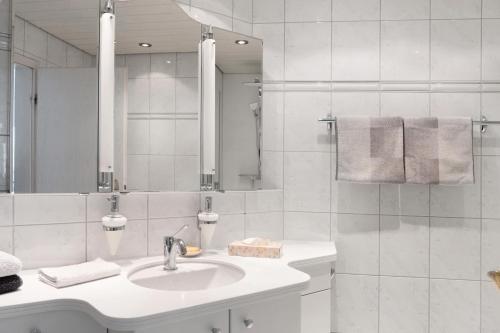 a white bathroom with a sink and a mirror at Ferienwohnung am Schlosssee in Salem