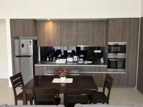 a kitchen with a black table and chairs and a kitchen with a counter at By The Sea Penang in Batu Ferringhi