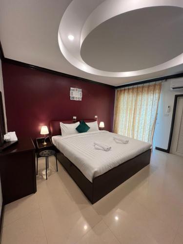 a bedroom with a large bed with a red wall at SVAH Boutique Patong in Patong Beach