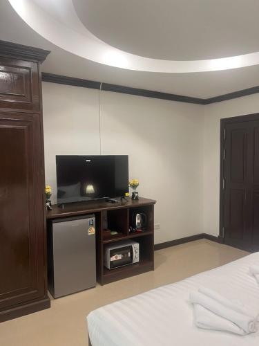 a room with a bed and a tv on a table at SVAH Boutique Patong in Patong Beach