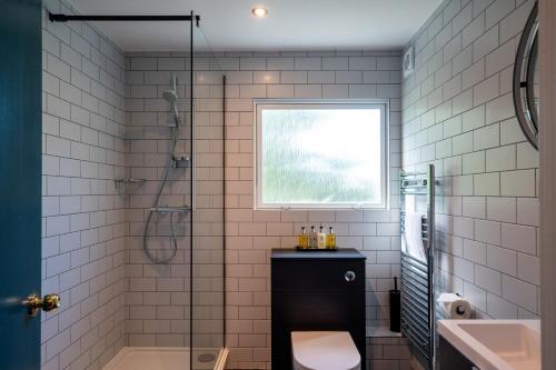 a bathroom with a shower and a toilet and a sink at The Conningbrook Hotel in Ashford