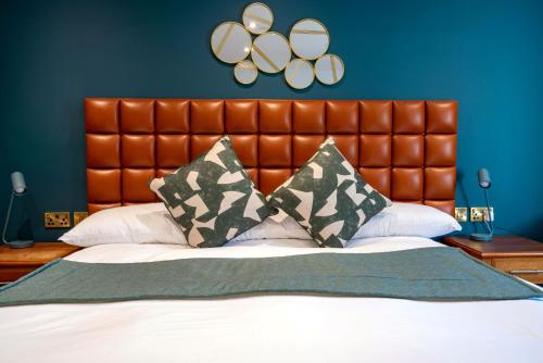 a bedroom with a large bed with a brown headboard at The Conningbrook Hotel in Ashford