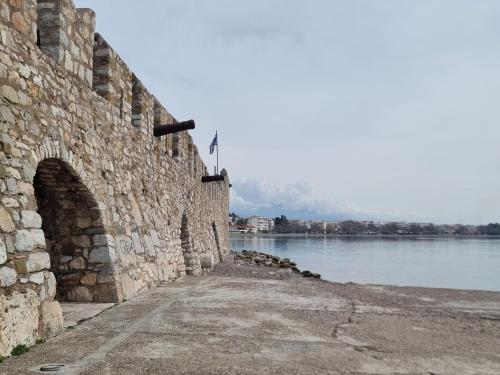 a stone wall next to a body of water at Place 2 Be in Nafpaktos