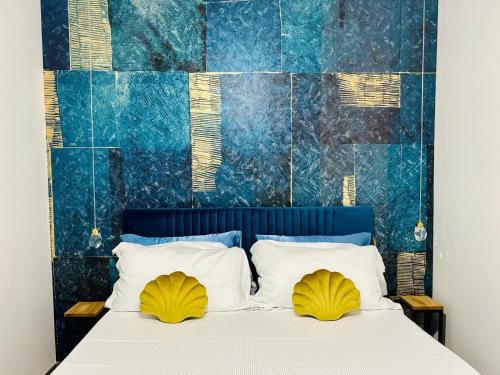 a bedroom with a bed with two yellow pillows at Il Rifugio Del Mare in Salerno