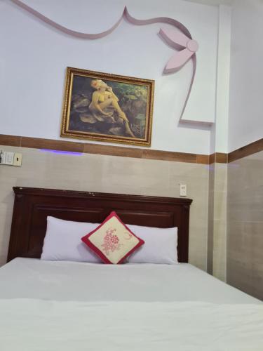 a bedroom with a bed with a picture on the wall at MOTEL 243 Long Thành-HOMESTAY 243 in Long Thành