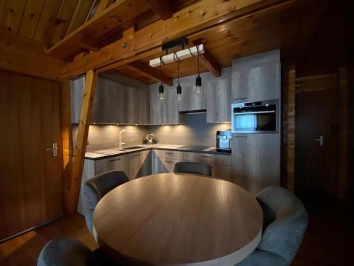 Una cocina con una mesa de madera y algunas sillas. en The Wooden Whisper, en Durbuy