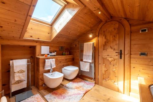 a bathroom with a toilet and a window at Alverà Lodge with Terrace R&R in Cortina dʼAmpezzo