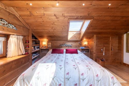 a bedroom in a log cabin with a large bed at Alverà Lodge with Terrace R&R in Cortina dʼAmpezzo