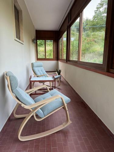 two chairs sitting in a room with windows at Tuscany Time in Montefoscoli