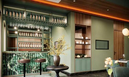 Un restaurante con un bar con un jarrón sobre una mesa. en Blessed Hotel Phu Quoc, en Phu Quoc