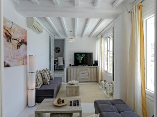 a living room with a couch and a tv at Villa in Mykonos with Sea View and Pool in Kalafatis