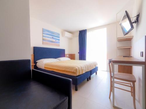 a bedroom with a bed with a blue headboard and a window at Hotel Angelo in Caorle