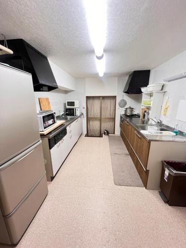 a large kitchen with white cabinets and appliances at 白馬蔵雲Zone in Hakuba