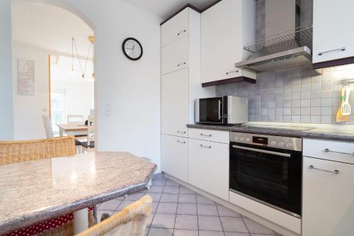 a kitchen with white cabinets and a black oven at Fasaneneck 14a in Grömitz