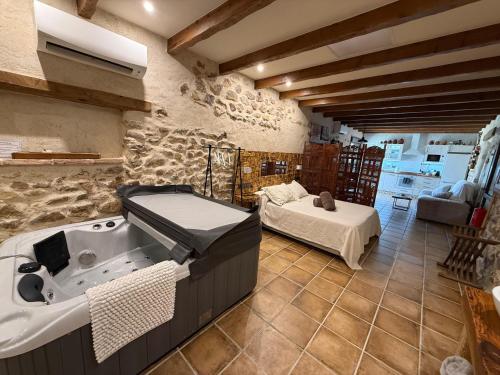 a bathroom with a tub and a bed in a room at El Rincón de San Juan in Marjaliza