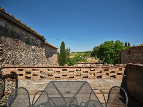 a table and chairs in front of a brick wall at Agriturismo Pometti - Fattoria La Selva in Trequanda