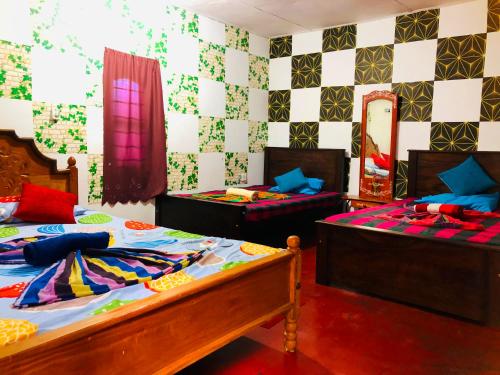een slaapkamer met 2 bedden en een spiegel bij Saman Restaurant - Family House in Arugam Bay