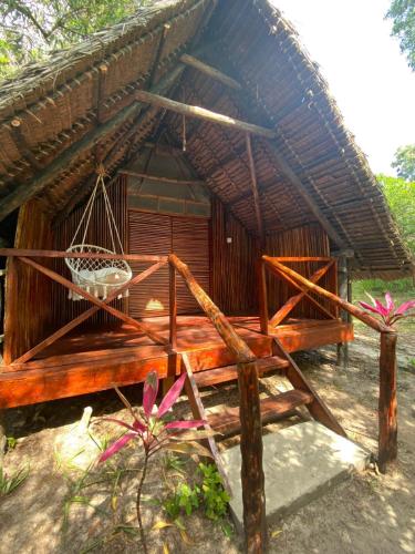 a wooden bed in front of a hut at Kimulimuli Green Heaven in Kilindoni