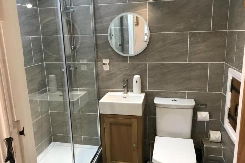 a bathroom with a shower and a toilet and a sink at Stylish 2 Bed Peak Dist Cottage Barn Alton Towers in Waterfall