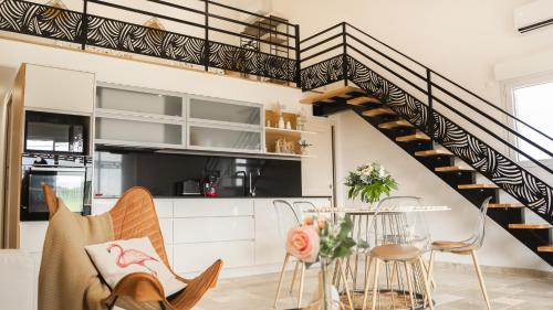 a kitchen and dining room with a spiral staircase at Pissenlit Une Prairie en Provence in Arles