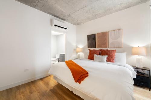 a bedroom with a large white bed with orange pillows at 4BR Corporate Suite Central and Modern in Chicago