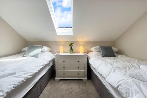 two twin beds in a room with a window at Camlad Barn in Chirbury
