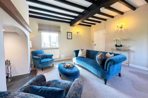 a living room with a blue couch and chairs at Marrington Farmhouse in Chirbury