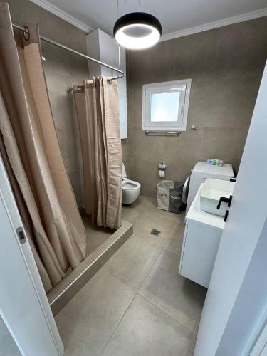 a bathroom with a shower and a toilet and a sink at Panorama Apartment in Kavála