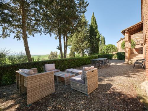 a patio with two couches and a table and chairs at Agriturismo Pometti - Fattoria La Selva in Trequanda