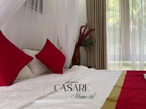 a bedroom with a bed with red and white pillows at Casare Phu Quoc - Formerly Caesar Hotel in Phu Quoc
