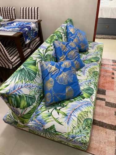 a couch with blue and green pillows on it at Royal Oceancrest Mactan - Relaxing Sunset View in Lapu Lapu City