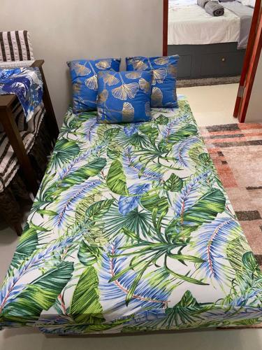 ein Bett mit einer bunten Bettdecke darauf in der Unterkunft Relaxing space with sunset view in Lapu Lapu City