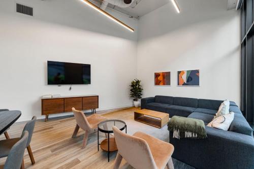 a living room with a blue couch and a tv at 4BR Corporate Suite Central and Modern in Chicago