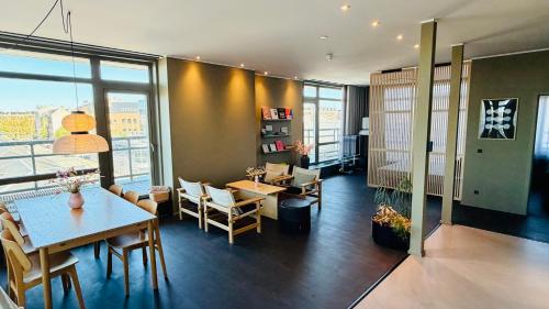 a room with a table and chairs and a room with windows at CPH Hotel in Copenhagen
