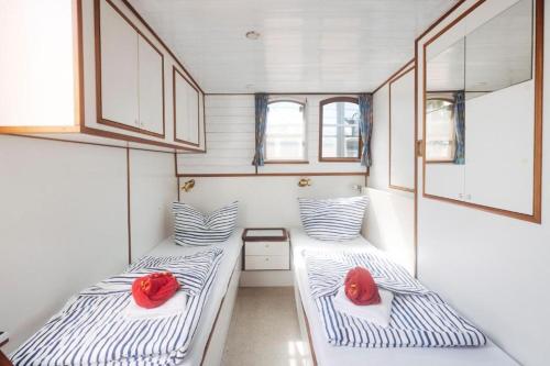 twee bedden in een kleine kamer met twee rode rozen bij Appartements Marina Niderviller in Niderviller