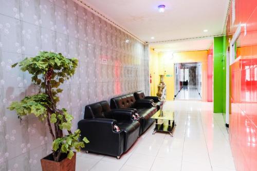 a lobby with a black couch and a green wall at Urbanview Hotel Mawar Sharon near Alun Alun Batu in Batu