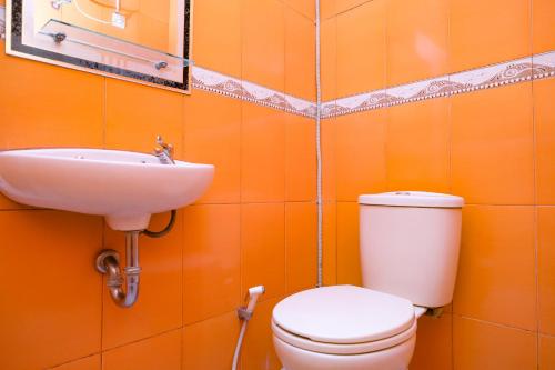 a bathroom with a toilet and a sink at Urbanview Hotel Mawar Sharon near Alun Alun Batu in Batu