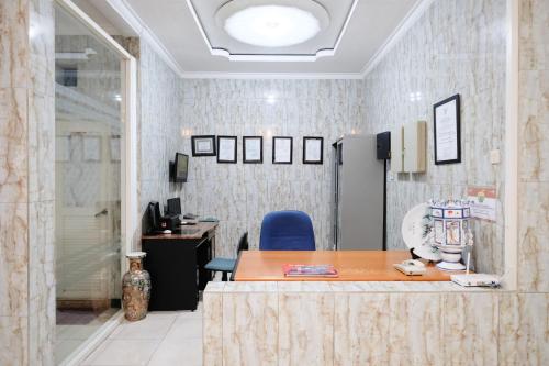 an office with a table and a blue chair at Urbanview Hotel Mawar Sharon near Alun Alun Batu in Batu
