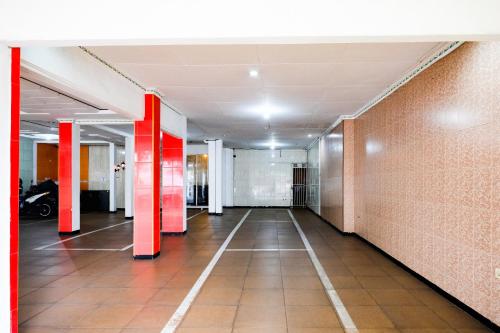 a hallway of an office building with red pillars at Urbanview Hotel Mawar Sharon near Alun Alun Batu in Batu